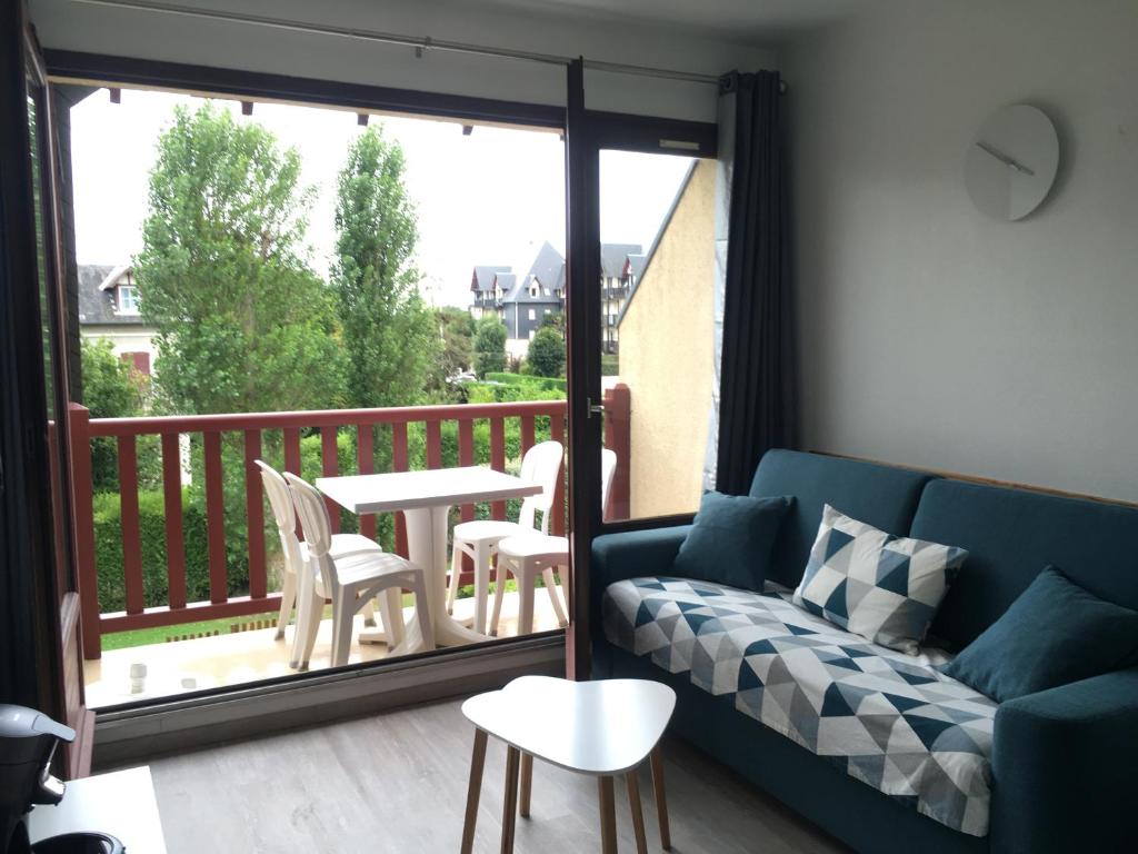 - un salon avec un canapé et une table sur un balcon dans l'établissement Cabourg, T2 parfait pour vous ! Proche plage et centre-ville, 2 à 4 pers., à Cabourg