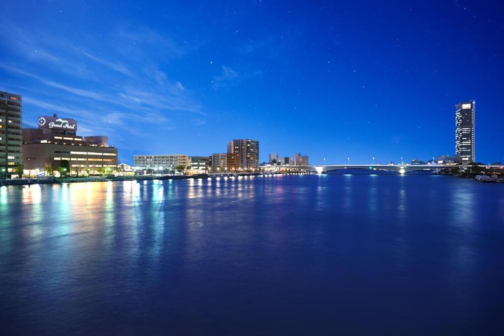 um horizonte da cidade à noite com um grande corpo de água em Niigata Grand Hotel em Niigata