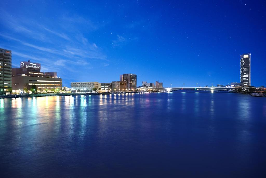a city skyline at night with a large body of water at Niigata Grand Hotel in Niigata