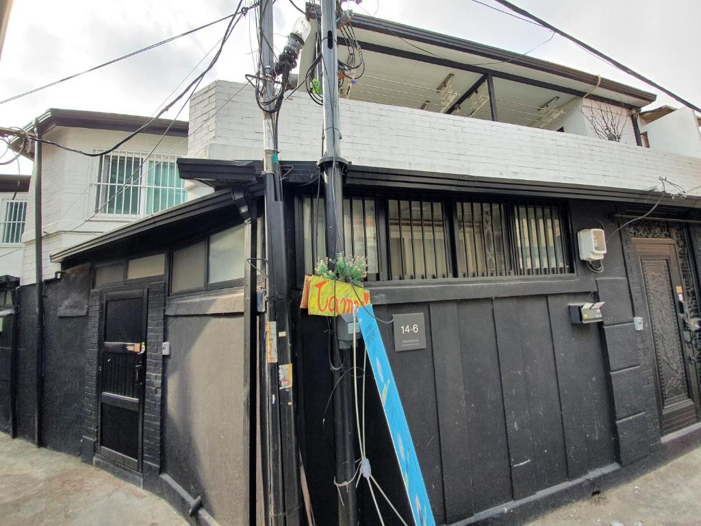 uma casa com uma garagem preta com uma mangueira em Jinho's Guest House em Seul
