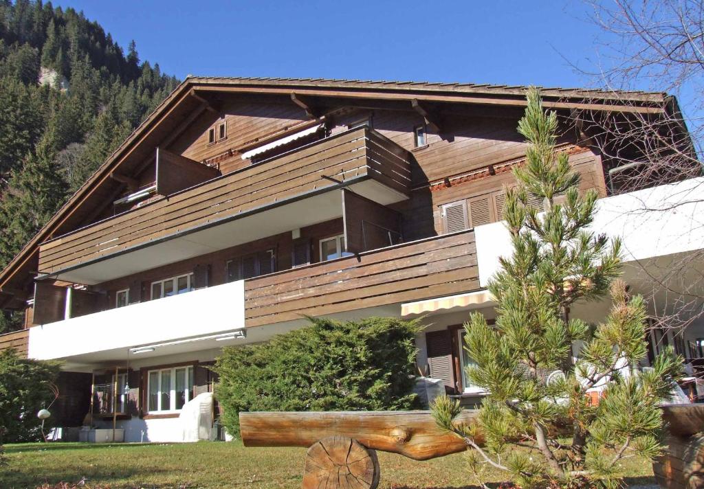 a house with a tree in front of it at Ferienwohnung Silberdistel in Adelboden
