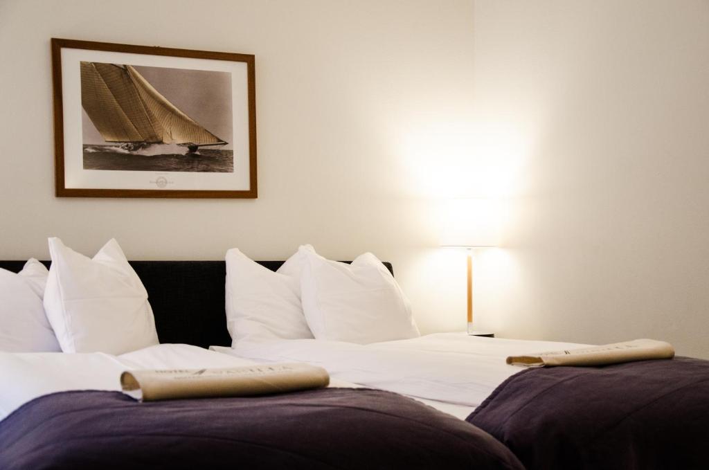 ein Schlafzimmer mit 2 Betten und einem Bild eines Segelboots in der Unterkunft Hotel Vanilla in Göteborg