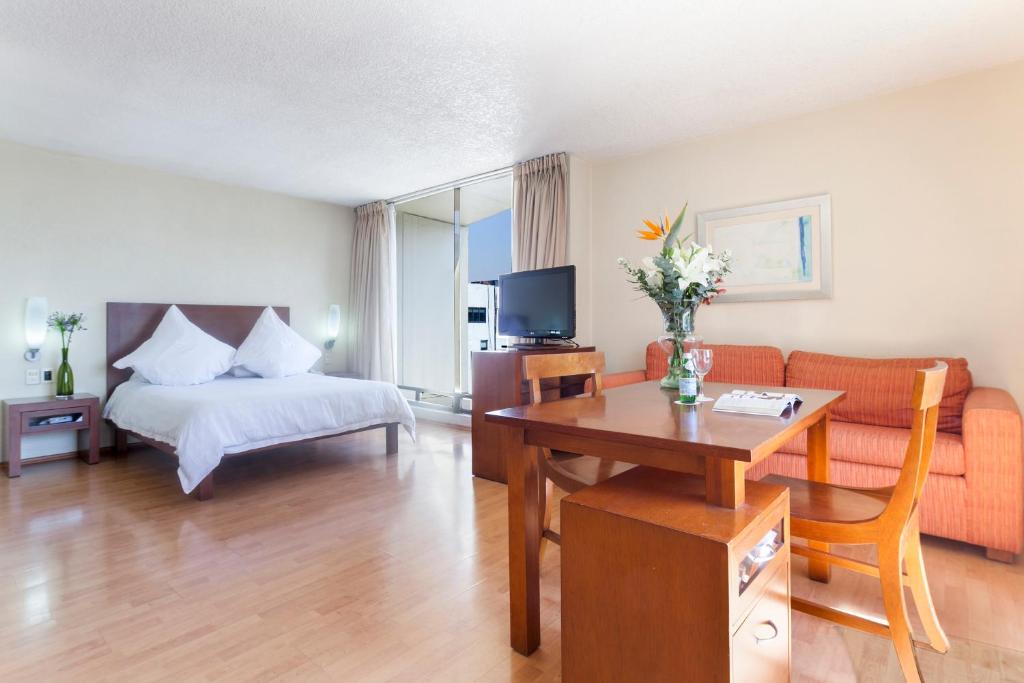 um quarto de hotel com uma cama, uma mesa e um sofá em Exe Suites San Marino em Cidade do México