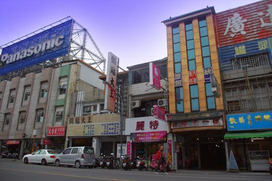 un groupe de bâtiments dans une rue urbaine avec des voitures dans l'établissement Uni Hotel, à Taïtung