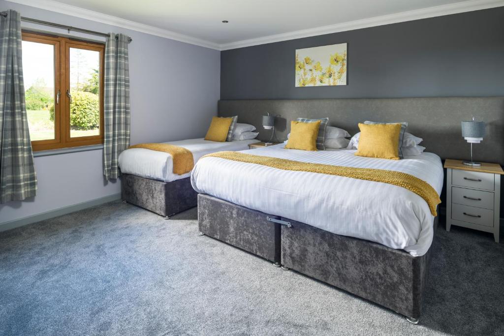 a bedroom with two beds and a window at Trethorne Hotel & Golf Club in Launceston