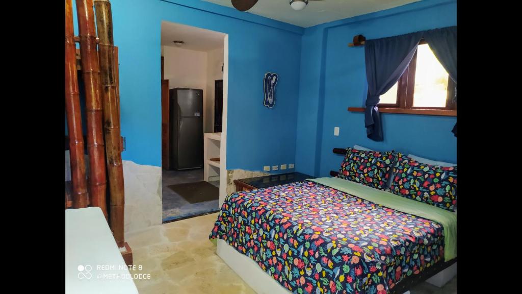 um quarto com uma cama e uma parede azul em Room in Lodge - Method Living Tropical Edition em Cabarete