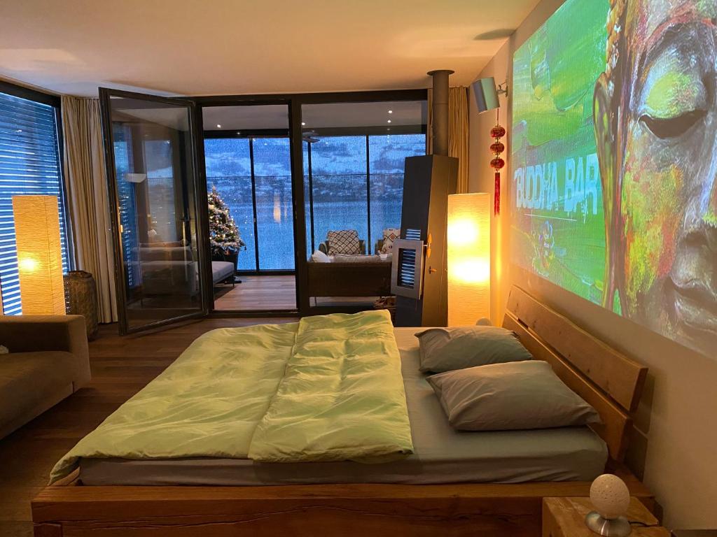 a bedroom with a large bed and a large screen at Luxury loft on top of Villa Wilen with tremendous views by the lake in Sarnen