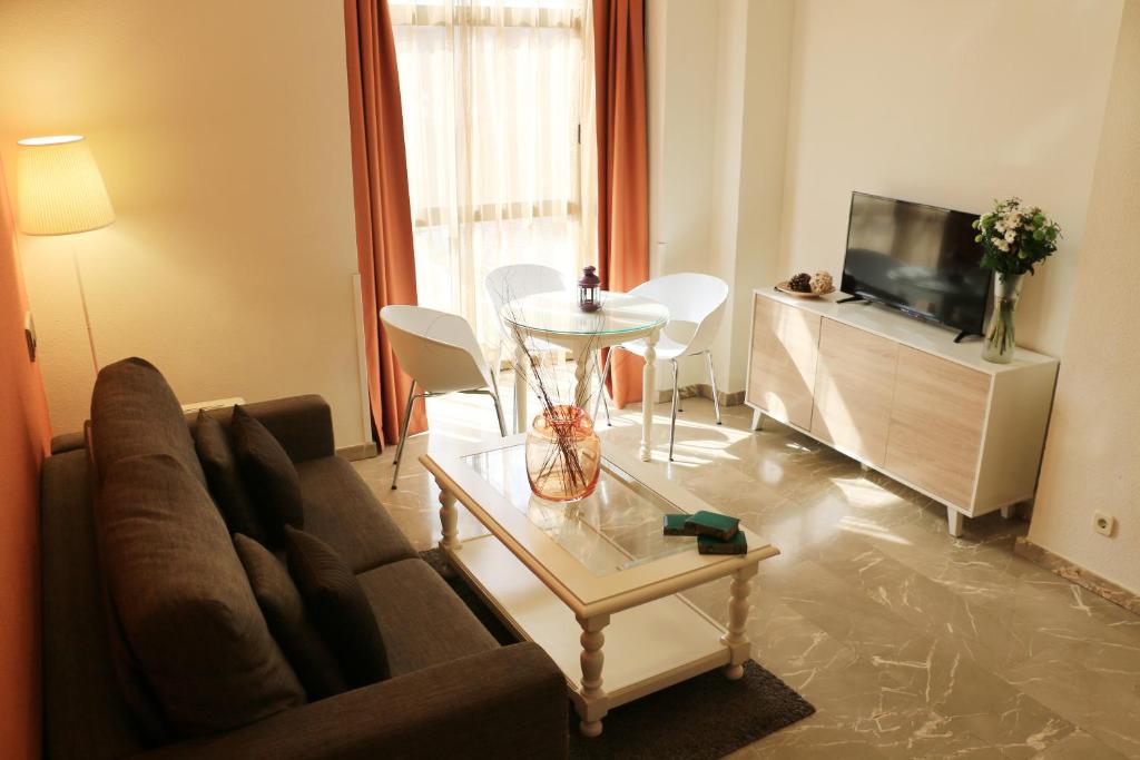 uma sala de estar com um sofá e uma mesa em Aparthotel G3 Galeon em Madri