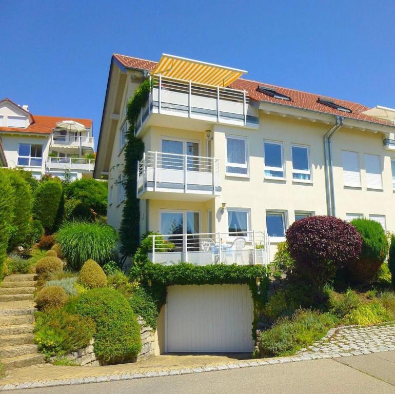 un gran edificio blanco con arbustos y árboles en Seeholiday - Ferienwohnung Korte, en Meersburg