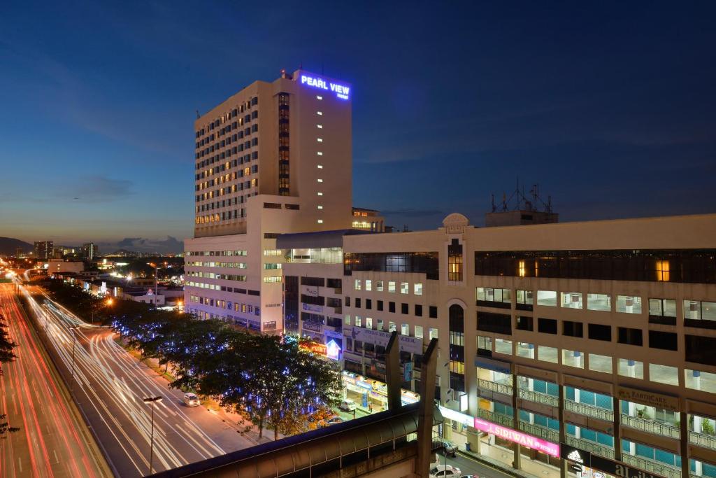 a tall building with lights on top of it at night at Pearl View Hotel Prai, Penang in Perai