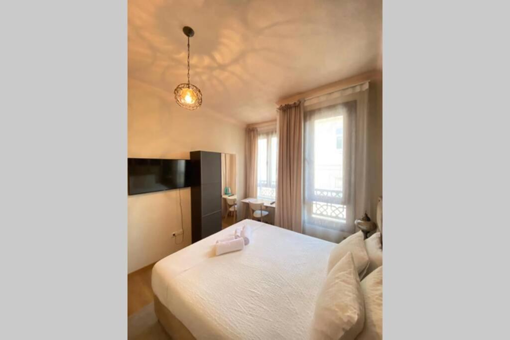 een slaapkamer met een wit bed en een televisie bij Duplex Suite Sultanahmet in Istanbul