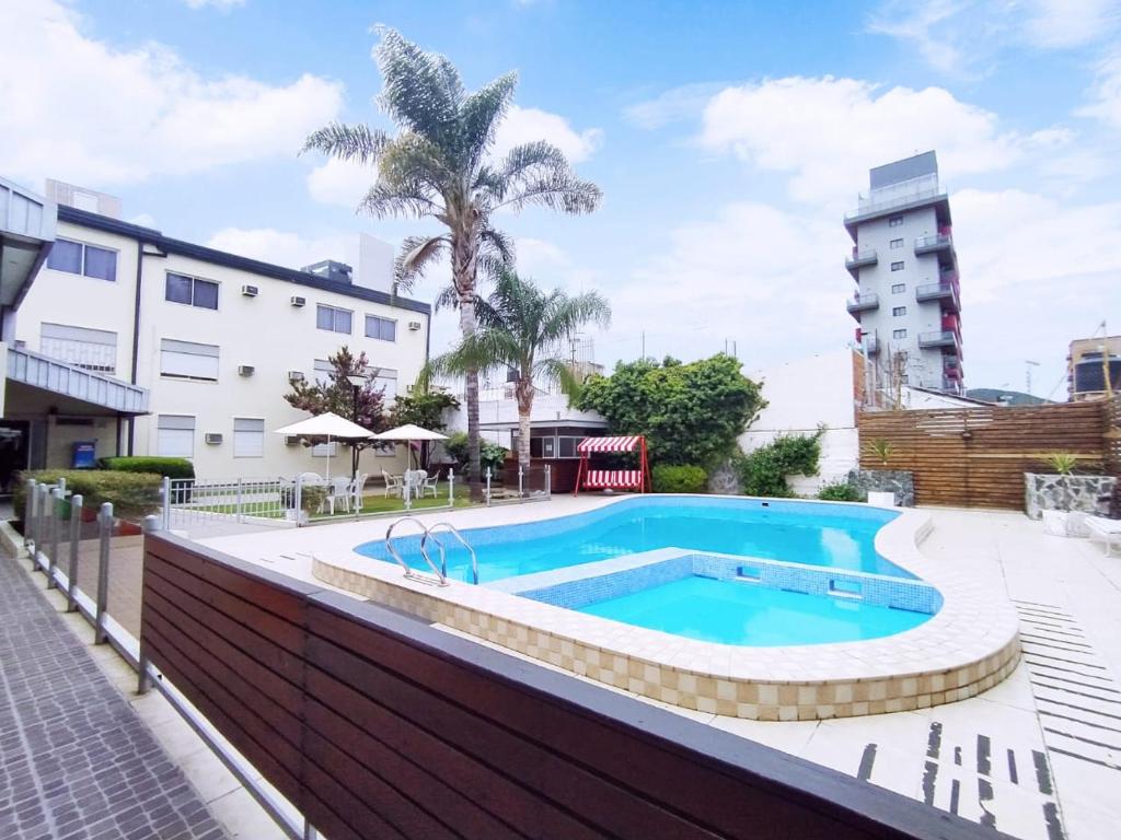 uma piscina em frente a um edifício em Gran Lourdes Hotel by CPH em Villa Carlos Paz