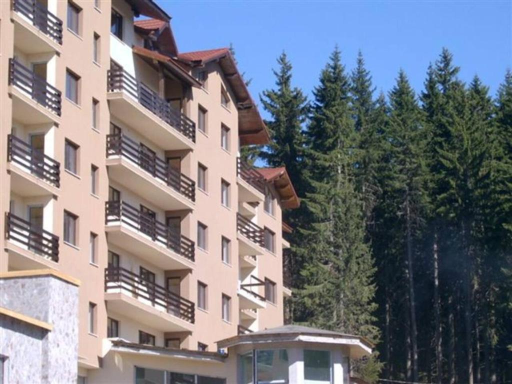 un grand immeuble d'appartements avec balcon et arbres dans l'établissement Stunning Mtn View 1-Bed Ski Apt in Pamporovo, à Pamporovo