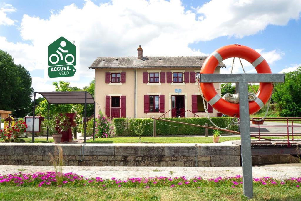 a sign and a life preserver in front of a building at MARA RIVIERE Gîte d'étape sur la Vélo Francette in La Jaille-Yvon