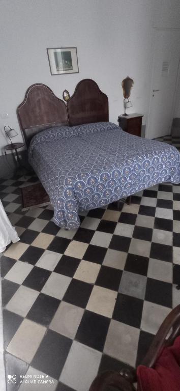 a bedroom with a bed and a checkered floor at Casa Cristina in Siracusa