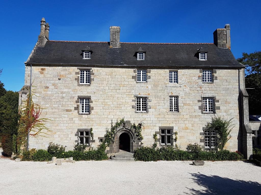 Un gran edificio de ladrillo con una puerta grande. en Appartement de charme au Manoir !, en Le Relecq-Kerhuon