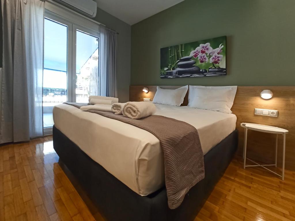ein großes Bett in einem Zimmer mit einem großen Fenster in der Unterkunft Athens Sweet Home in Athen