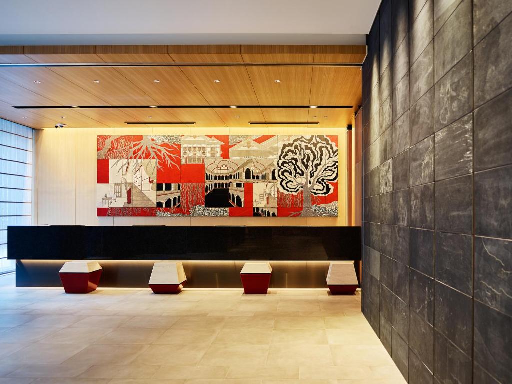 a lobby with benches and a painting on the wall at Mitsui Garden Hotel Ginza-gochome in Tokyo