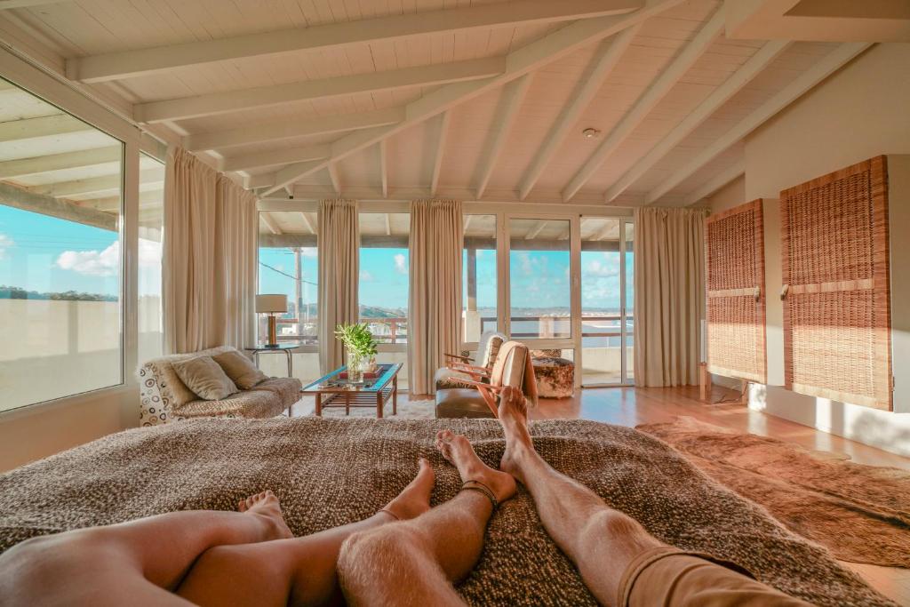 two people laying on a bed in a living room at Brisas de La Pedrera Hotel Boutique in La Pedrera