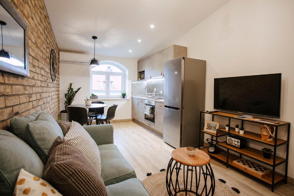 a living room with a couch and a flat screen tv at Unique city center Apartments Gran Fenice with free garage parking and roof terrace in one of the apartments in Rijeka