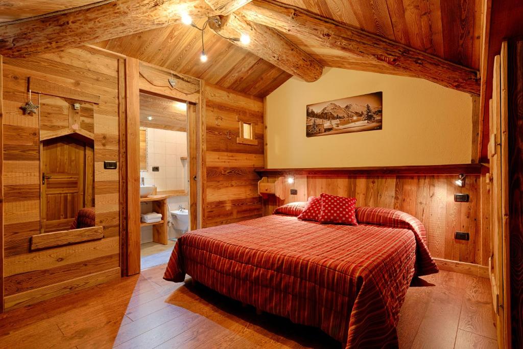 アイマヴィルにあるHotel Rendez-Vous - Aymavillesの木製の壁のベッドルーム1室(ベッド1台付)