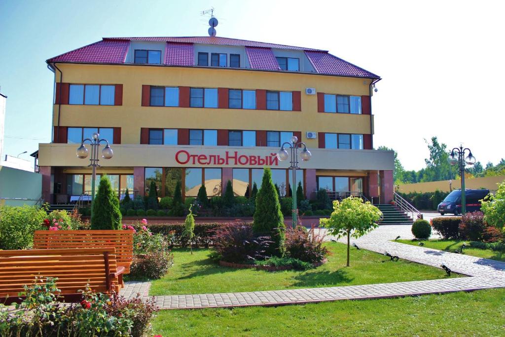 un bâtiment avec un panneau devant lui dans l'établissement Noviy Otel, à Smolensk
