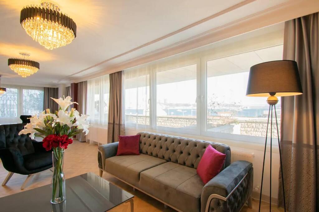 a living room with a couch and a large window at Delightful Residence Maiden Tower in Istanbul