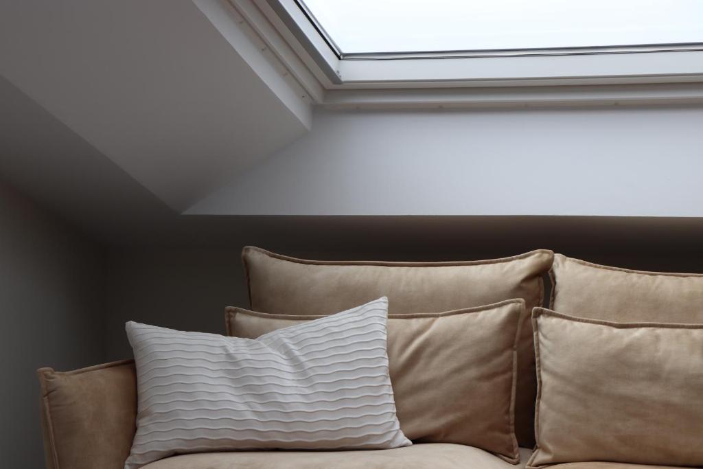 a skylight in a room with a couch with pillows at La Panadería in El Rompido