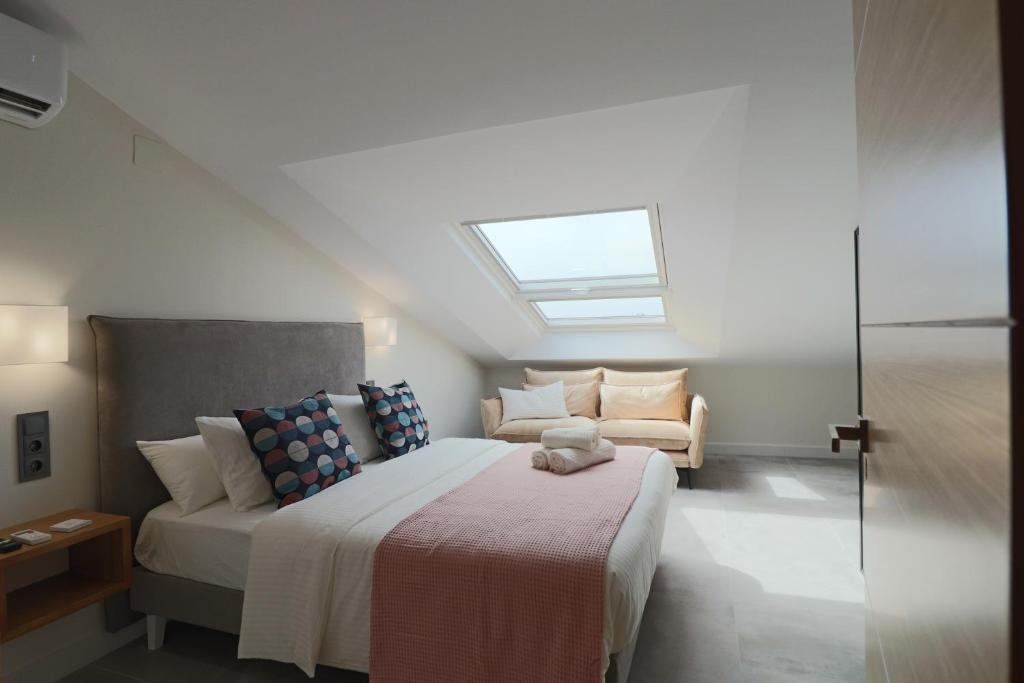 a bedroom with a bed and a couch and a window at La Panadería in El Rompido