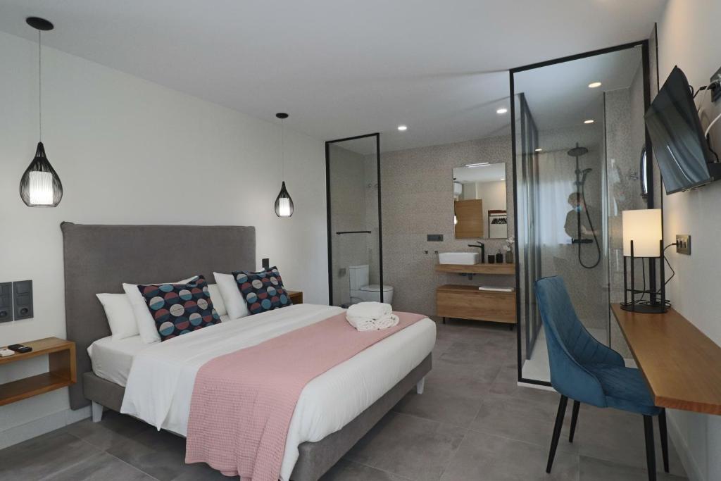 a bedroom with a large bed and a desk at La Panadería in El Rompido