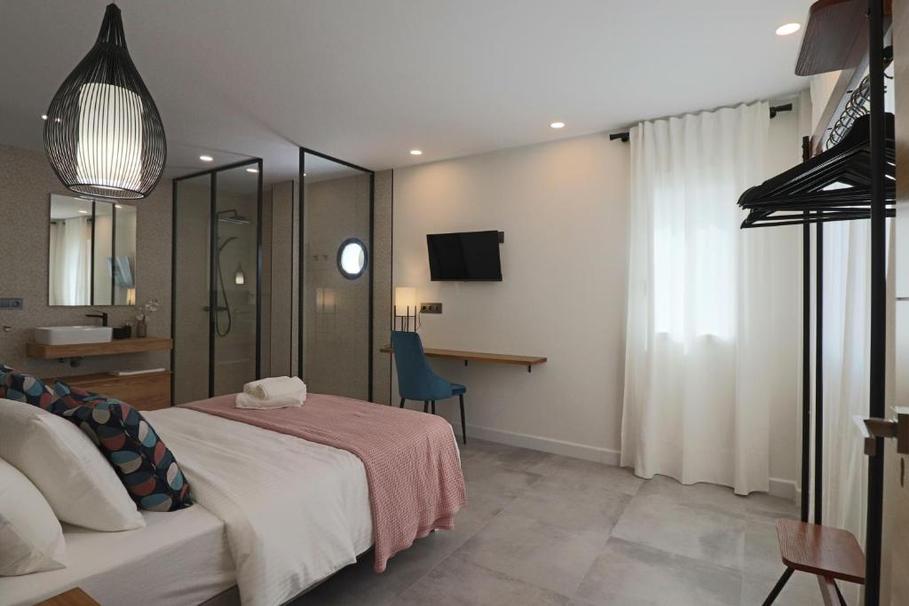 a bedroom with a bed and a desk and a television at La Panadería in El Rompido
