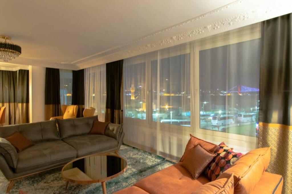 a living room with a couch and a large window at Royal Residence Maiden Tower in Istanbul