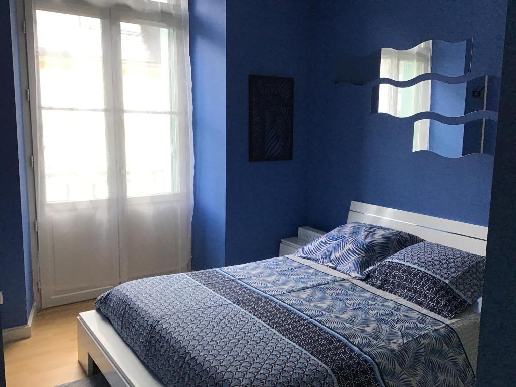 um quarto azul com uma cama com paredes azuis em Appartement 5 couchages coquet proche centre em Cauterets