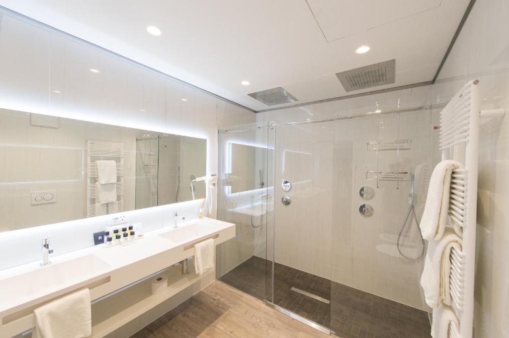 a bathroom with a shower and a sink and a mirror at Grand Hotel Liberty in Riva del Garda