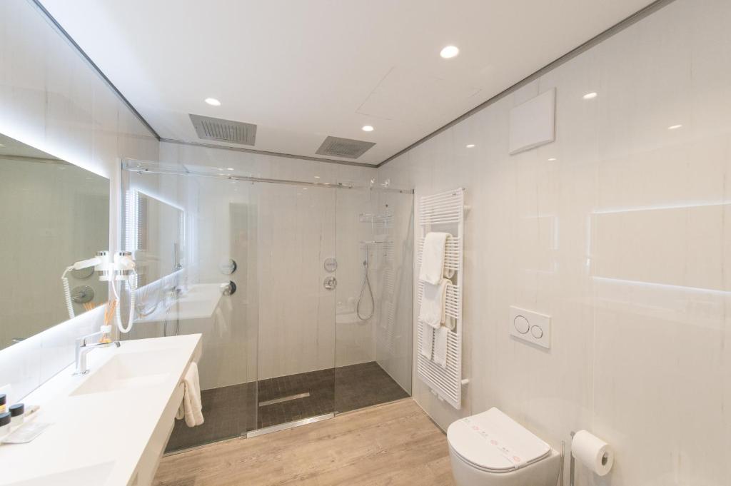 a bathroom with a shower and a toilet and a sink at Grand Hotel Liberty in Riva del Garda
