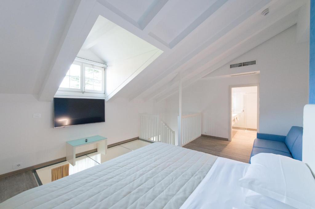 a bedroom with a white bed and a blue couch at Grand Hotel Liberty in Riva del Garda