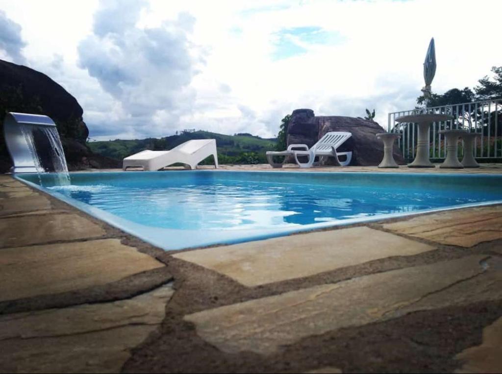 a swimming pool with blue water in a resort at Chácara Recanto das Pedras - Socorro/SP - WiFi e Pebolim in Socorro