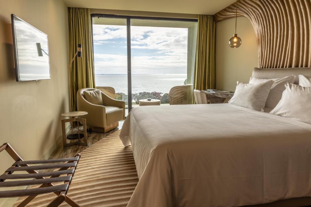 a hotel room with a bed and a large window at Vila Foz Hotel & SPA - member of Design Hotels in Porto