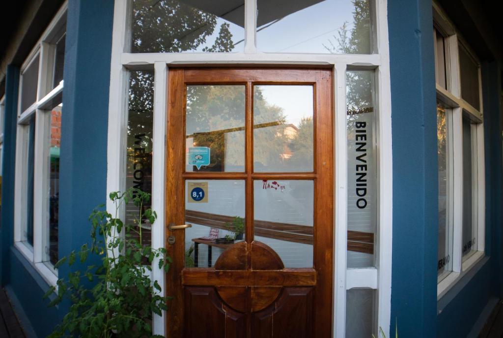 una puerta a una casa con ventana en Pinamar Hostel Casa de Verano en Pinamar