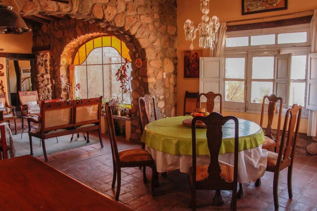 a dining room with a table and a stone wall at El Rastrojo - Casa de campo in Tilcara
