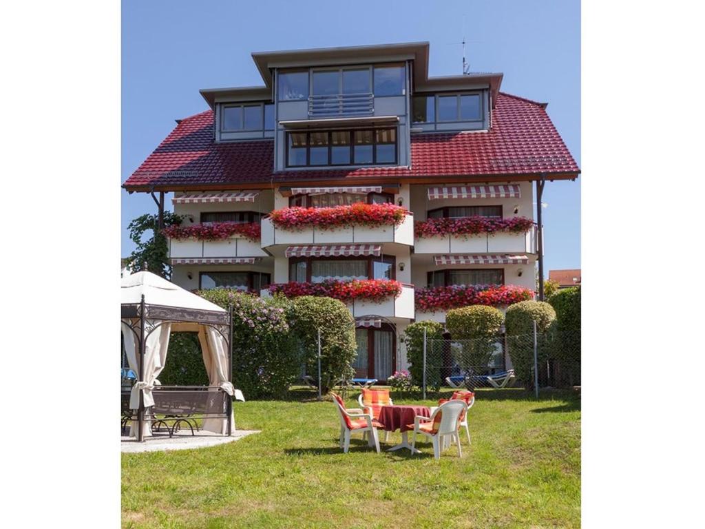 een huis met een tafel en stoelen ervoor bij Hotel Seepark Appartements in Uhldingen-Mühlhofen