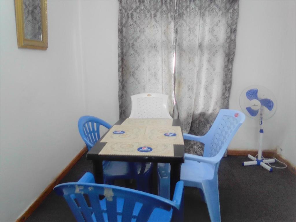 a table and four chairs in a room at Fish Eagle Backpackers in Lusaka