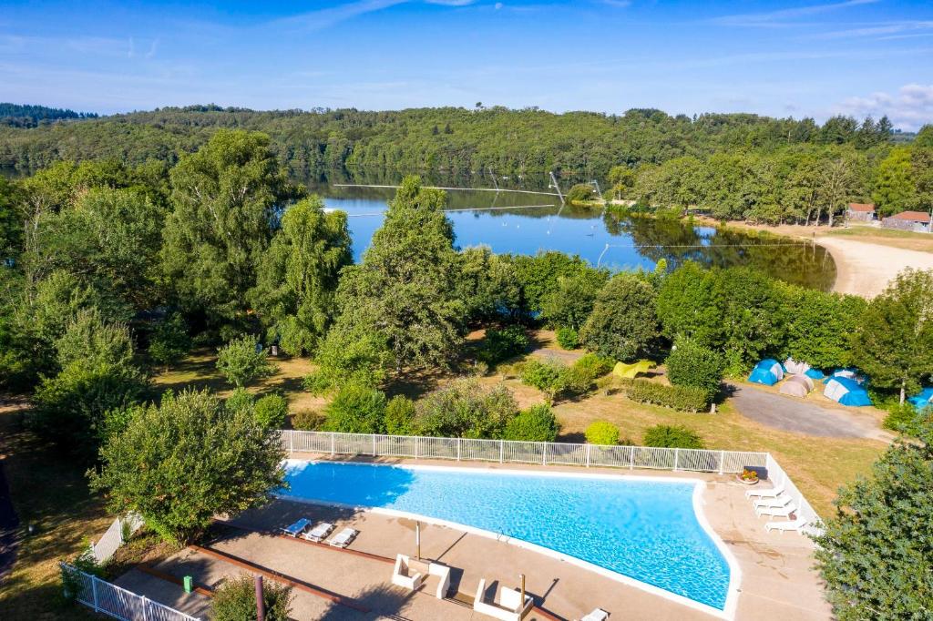 an aerial view of a swimming pool and a lake at Camping du Lac de Saint-Pardoux in Saint-Pardoux