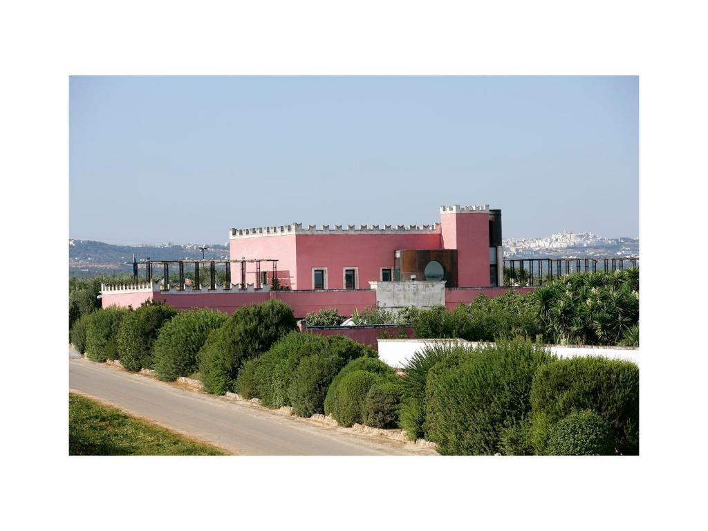 a road in front of a pink building at Grand Hotel Masseria Santa Lucia in Ostuni
