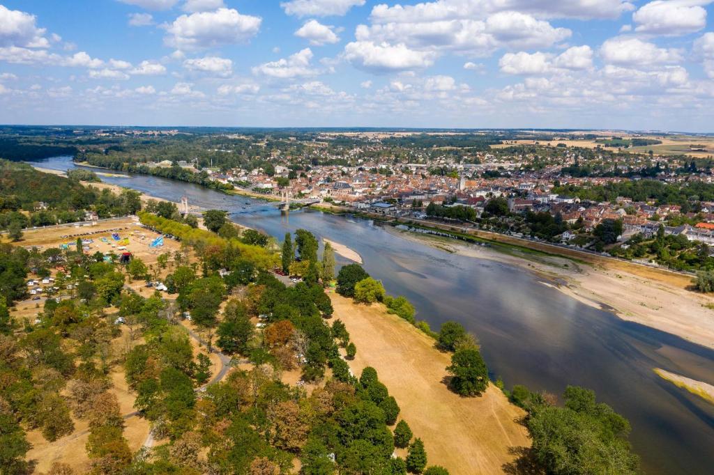 an aerial view of a river and a city at Camping de l'île in Bannay