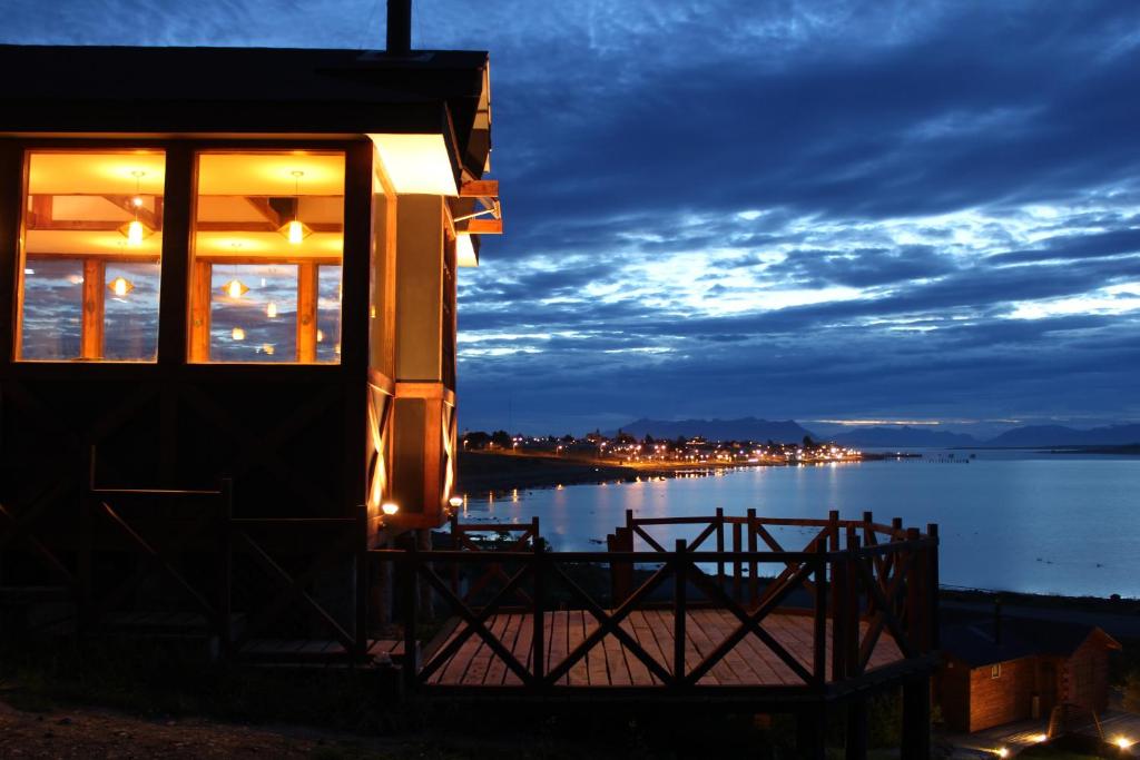 a building with a view of the water at night at Weskar Lodge Hotel in Puerto Natales