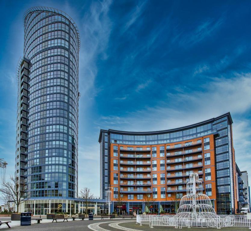 deux grands bâtiments avec une fontaine devant eux dans l'établissement Gunwharf Quays Apartments, à Portsmouth