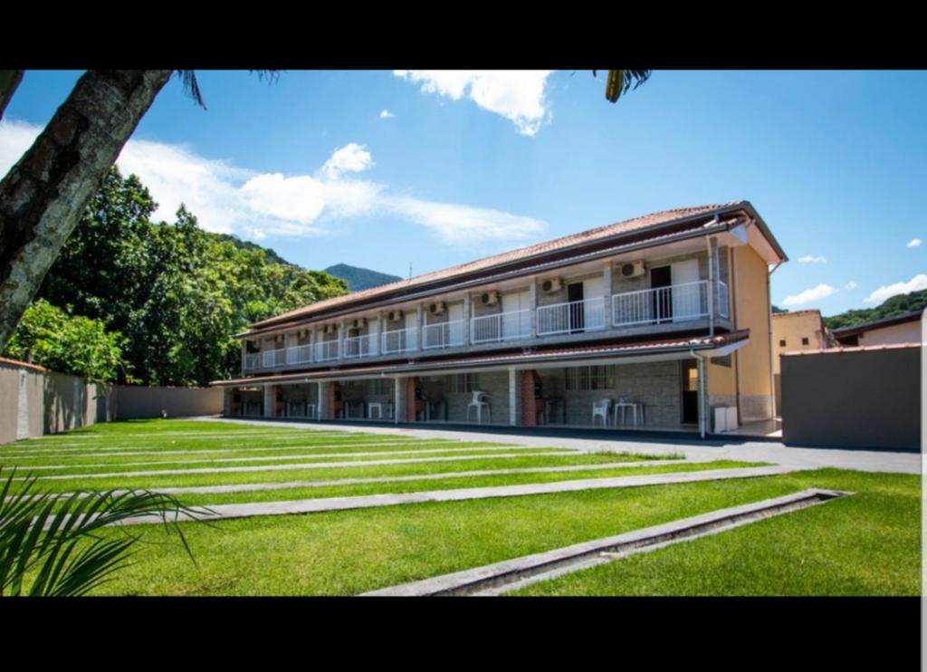 un grand bâtiment avec une pelouse devant lui dans l'établissement Villaggio Avansi, à Caraguatatuba