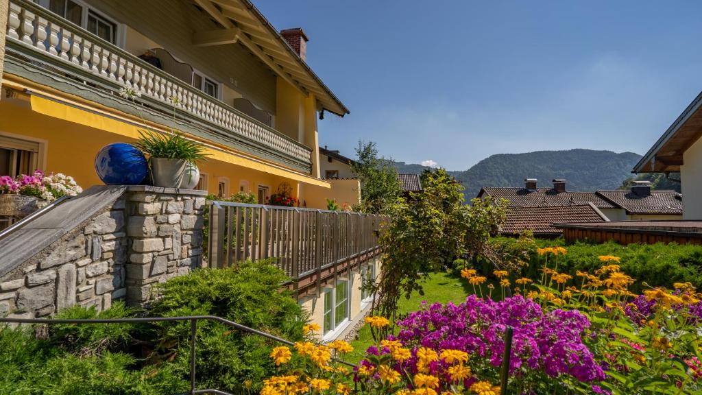 a garden in front of a house with flowers at Hotel Steffl Garni in Ruhpolding