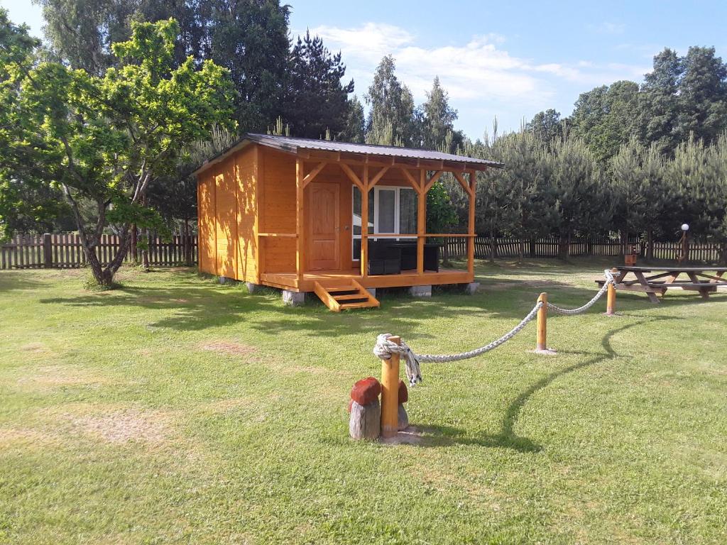 une petite cabine dans l'herbe avec une chaîne dans l'établissement Kempings Jūrmalnieki, à Mazirbe
